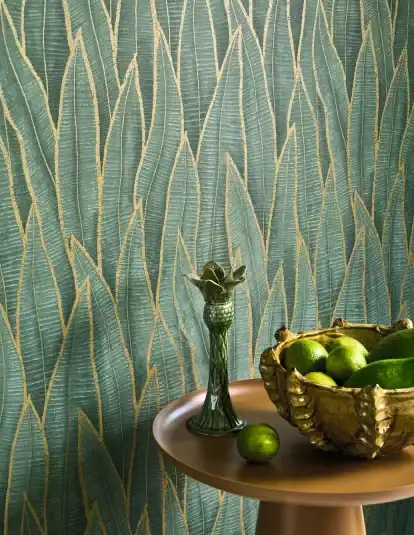 Modern living room interior featuring a tropical accent wall with Casadeco Sansevieria Vert Paon wallpaper, styled with contemporary furniture and natural lighting.