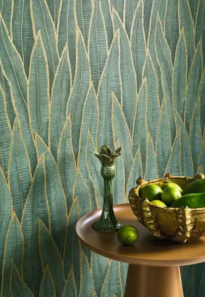 Modern living room interior featuring a tropical accent wall with Casadeco Sansevieria Vert Paon wallpaper, styled with contemporary furniture and natural lighting.