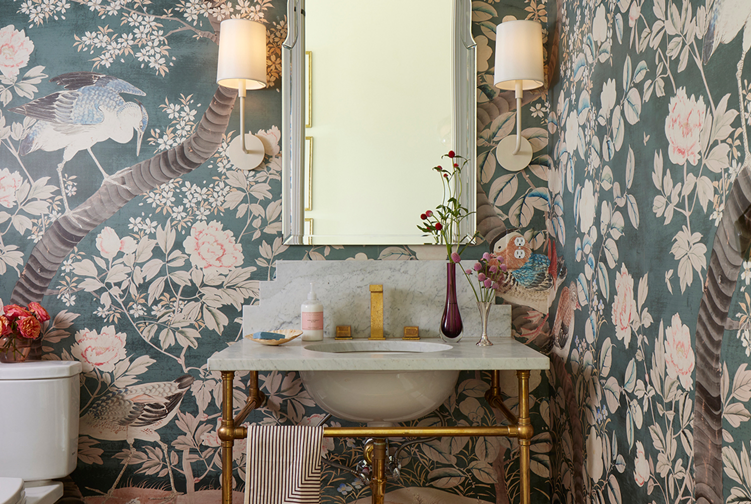 A powder room with a bold, floral wallpaper.