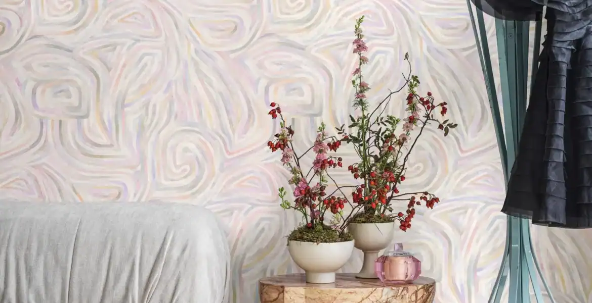 Instalation de Papier peint Cole & Son Kawakubo Ochre & Stone dans un chambre a couchee revele des tons ocre et gris pierre.