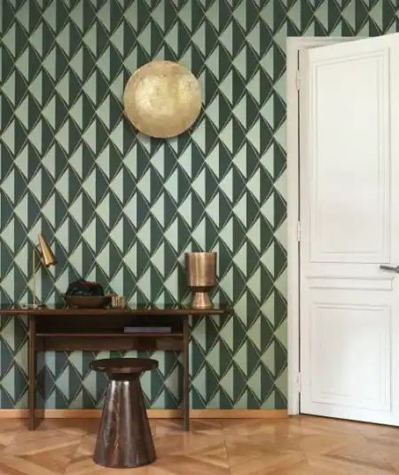 Papier peint Casadeco Chaplin avec motif géométrique vert et or, parfait pour un salon moderne.